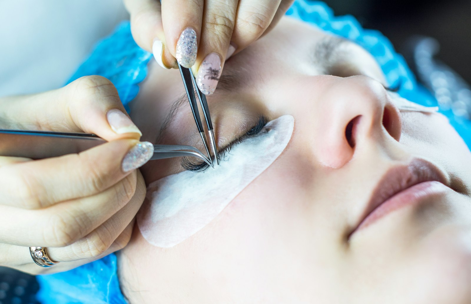 Lash technician applying eyelash extensions at AS Art Beauty Salon