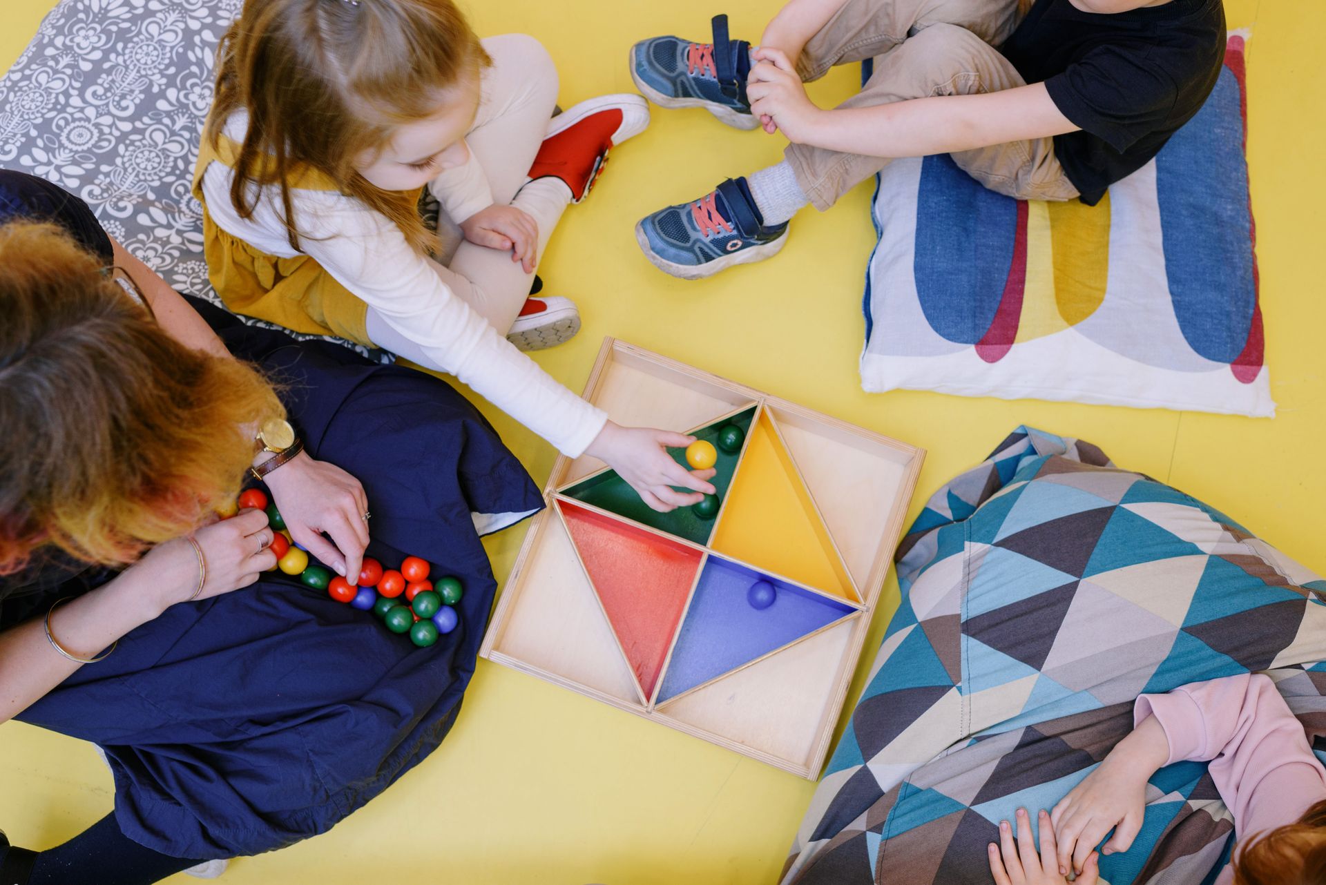 Children playing with a colourful Montessori activity tray at Dromina Community Playschool