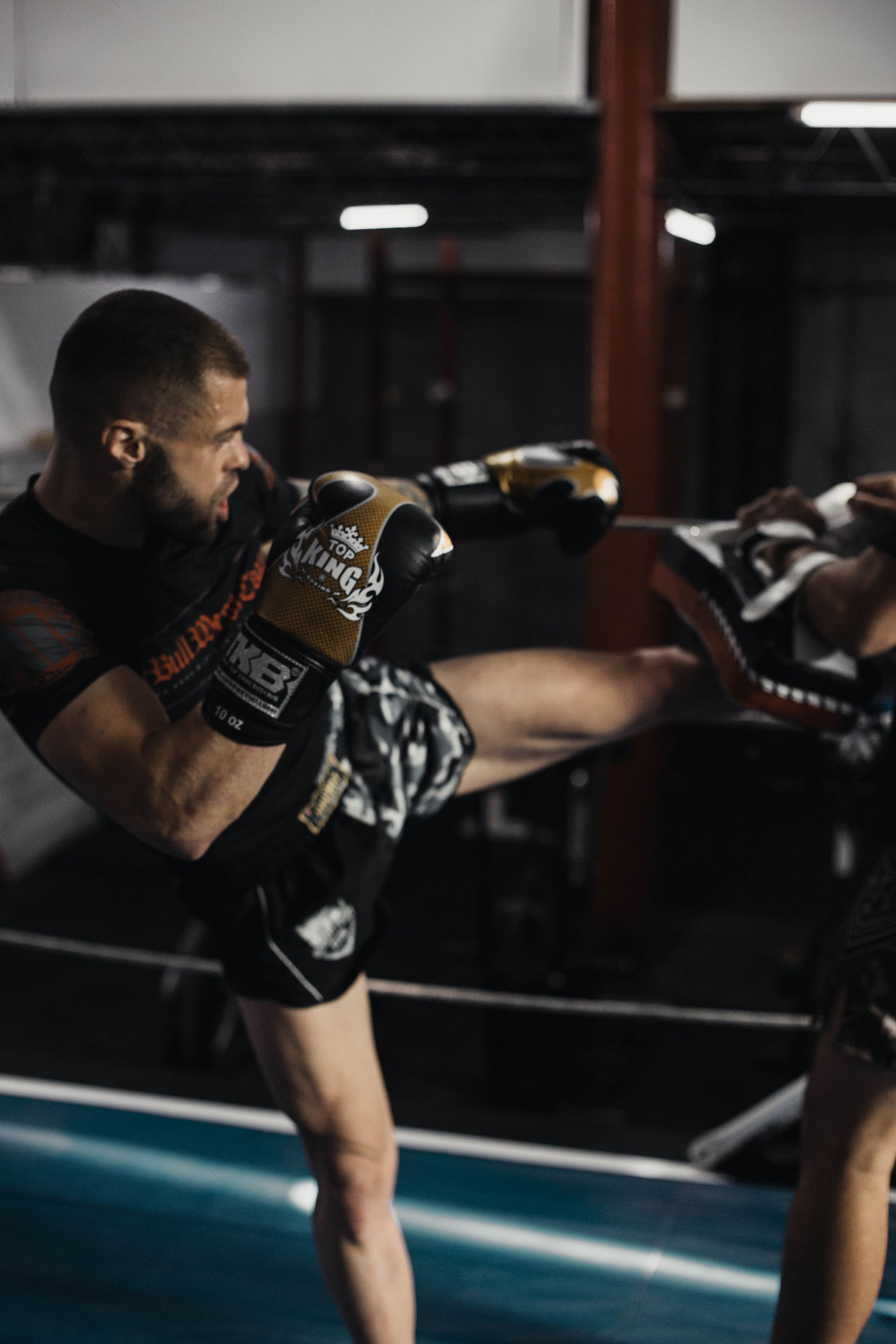 An Onyx Fight Club athlete throwing a high kickboxing kick during pad work