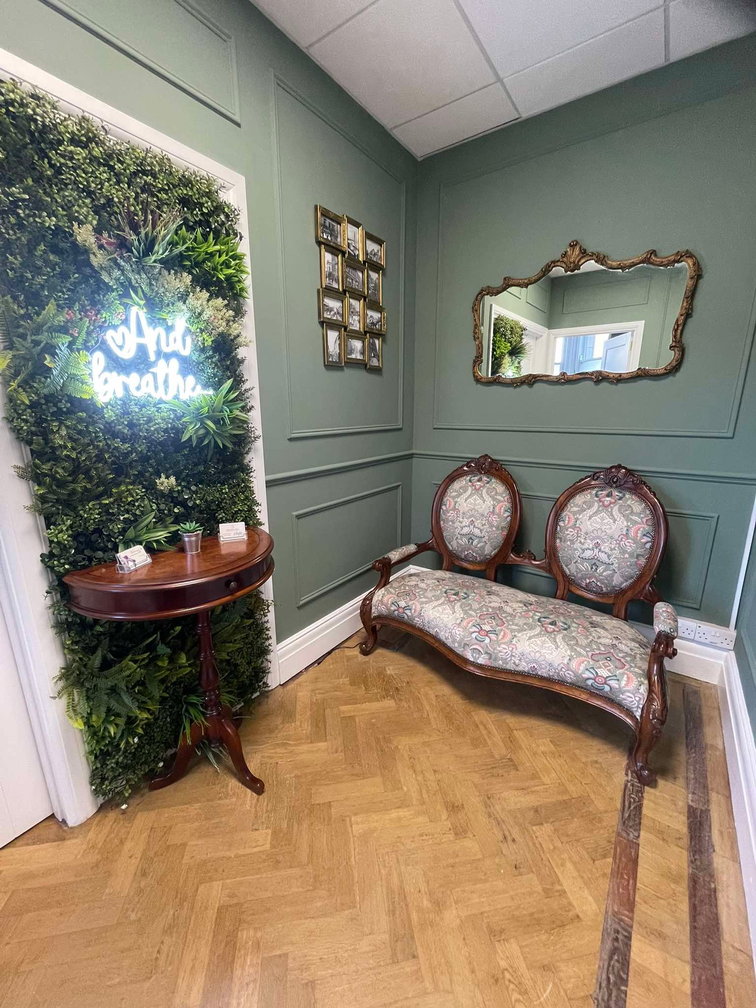 Cosy waiting area with vintage seating and a green living wall