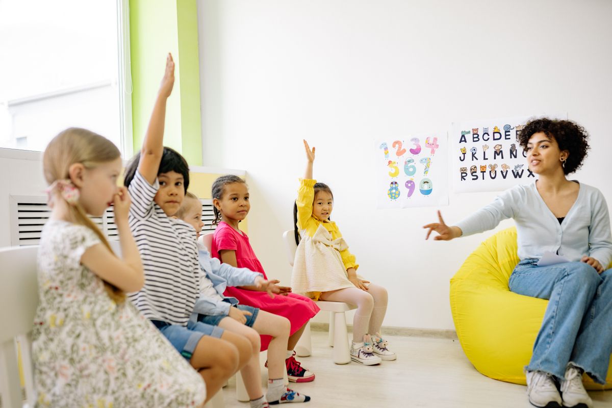 Children raising hands during a preschool activity at Rising Stars Childcare
