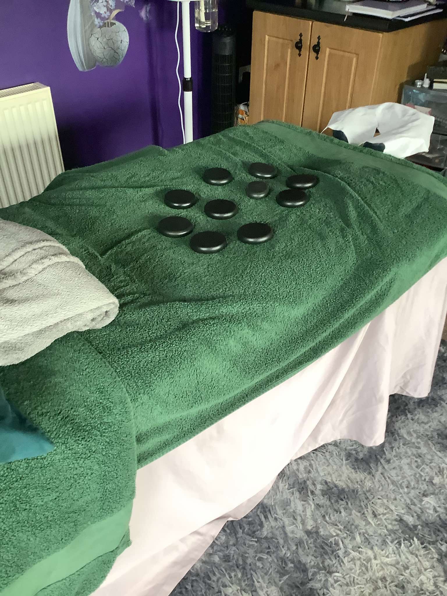 Hot stones arranged on a massage table in a treatment room
