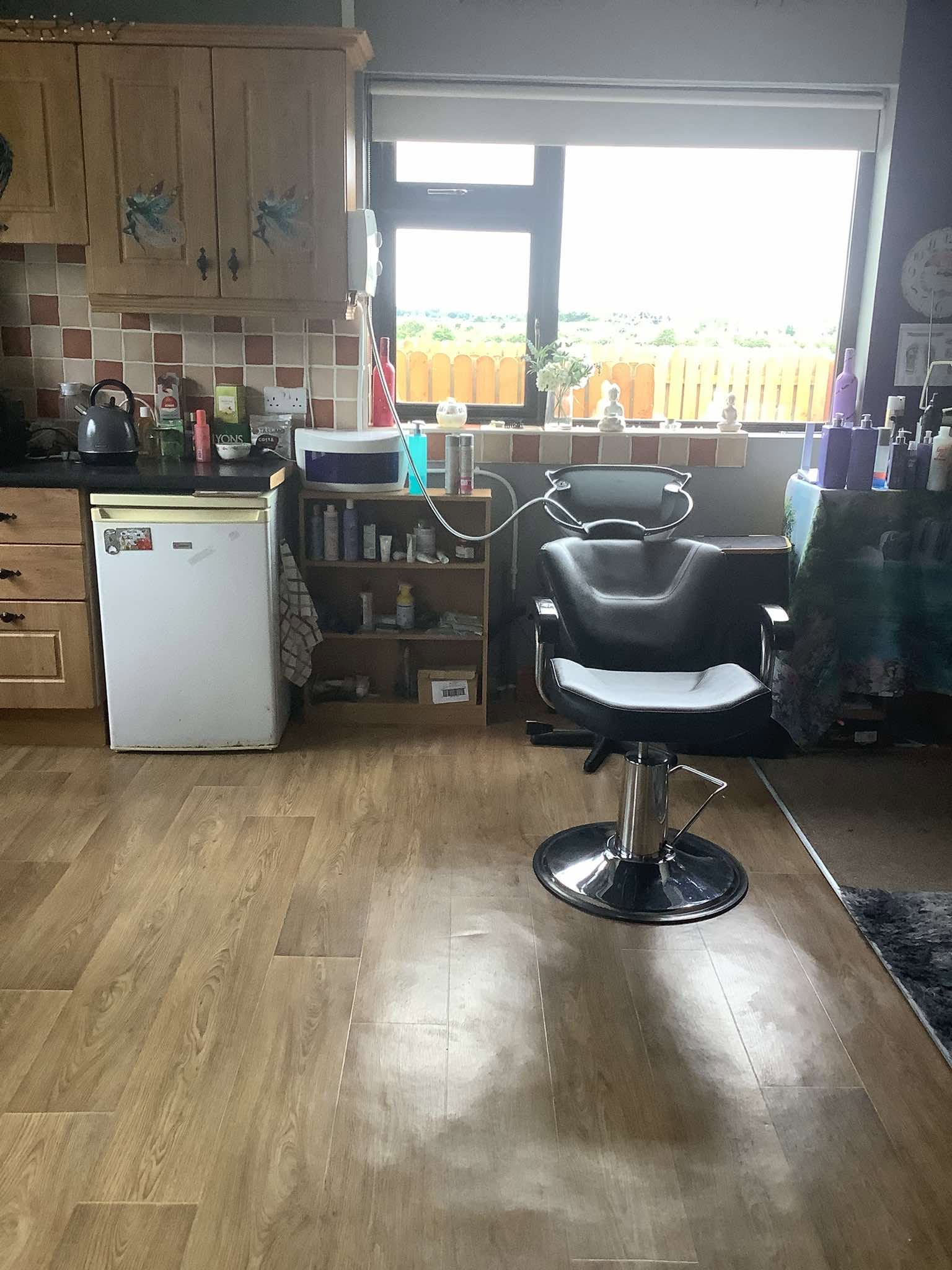 Hair washing chair and styling area beside a bright window