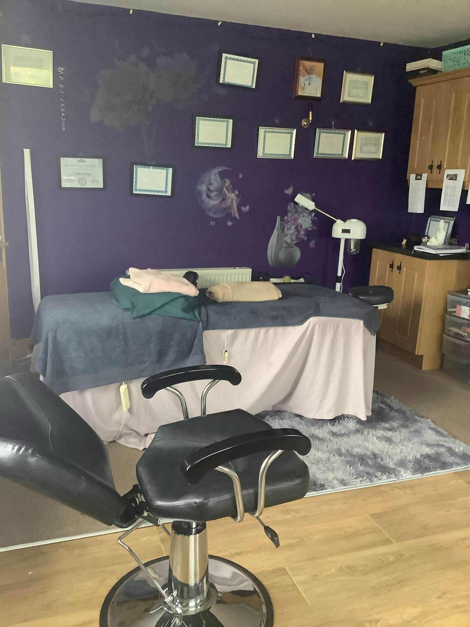 Treatment room with therapy tables and qualifications on display