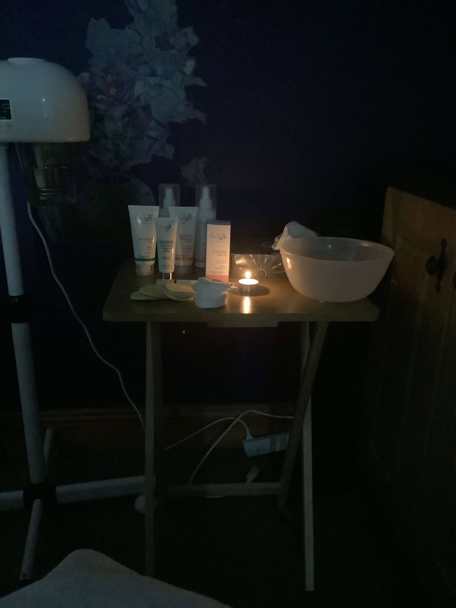 Facial skincare products set out by candlelight