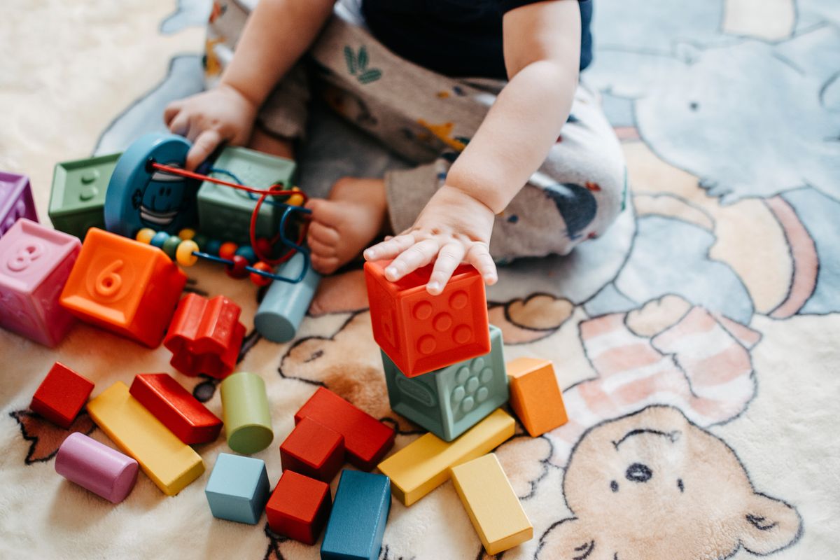 Toddler playing with colourful building blocks