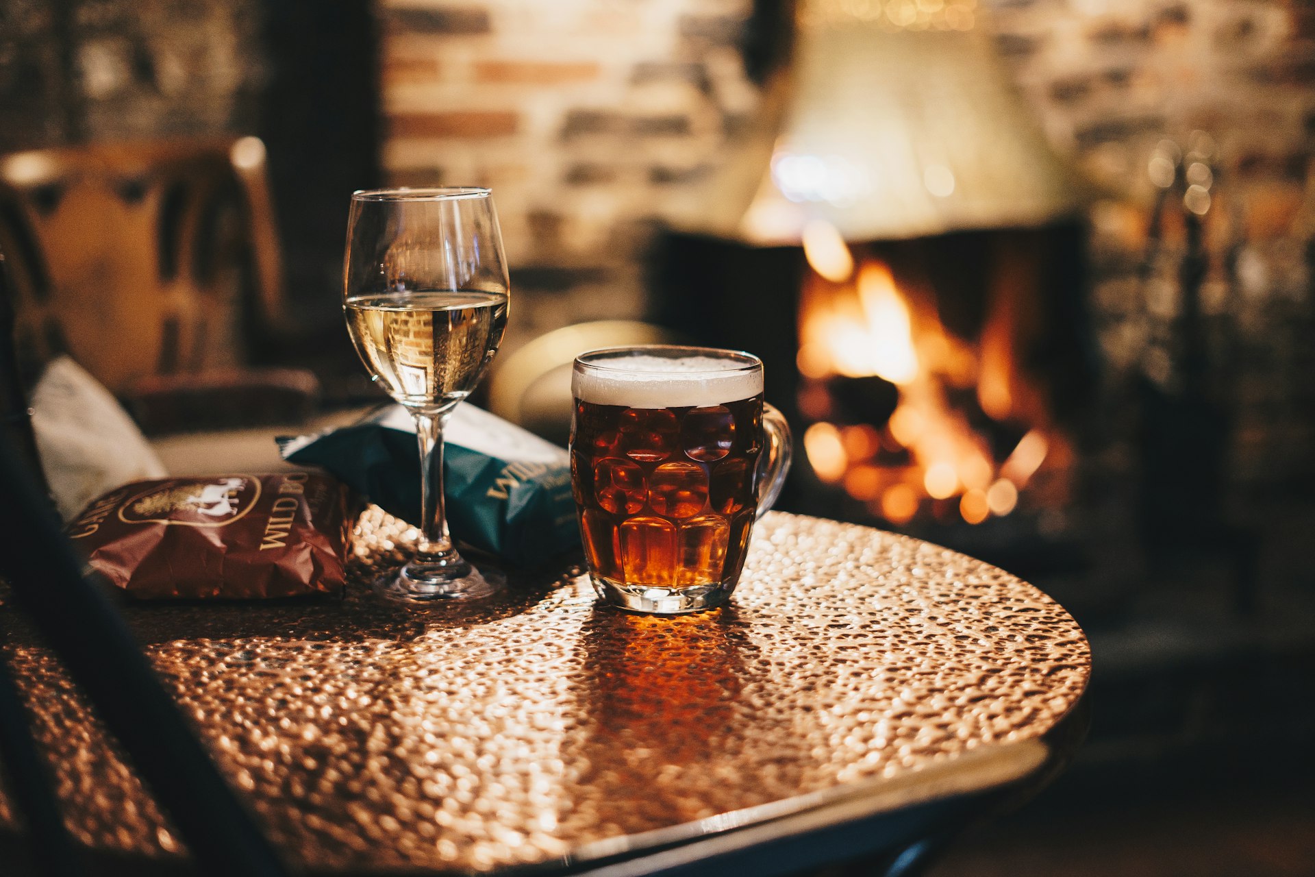 Cosy traditional bar interior with a pint by the fire